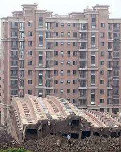 Un edificio di tredici piani in costruzione  crollato a Shanghai. Il palazzo in realt si  come inclinato tutto su di un lato, restando quasi intatto. Morto un operaio 28enne (Reuters)